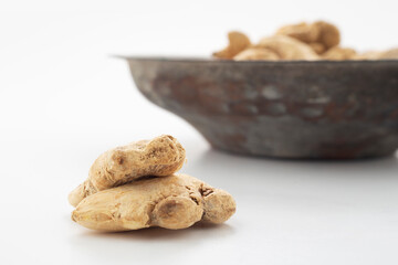 Ginger grains in white background and old copper bowl