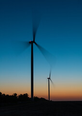 Fototapeta na wymiar Sulhouettes of wind turbines after sunset