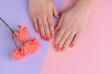 Orange coral nails and lisianthus. Perfect manicure and nail health
