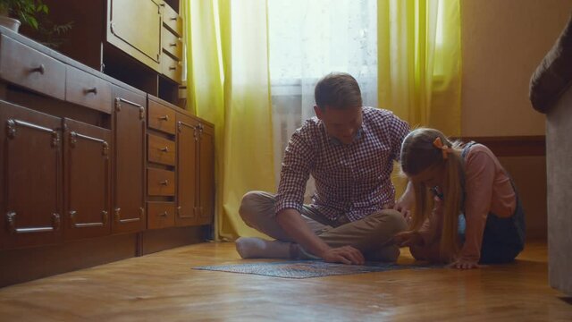 Dad and daughter with puzzle at home