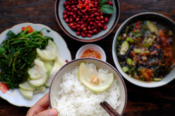 people have lunch, hand hold rice bowl with Vietnamese vegan food background