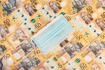 Disposable face mask over an australian dollar background.