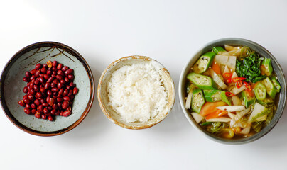 Top view Vietnamese vegan cuisine, family meal, vegetables sour soup, fried peanut with soy sauce and rice bowl for lunch