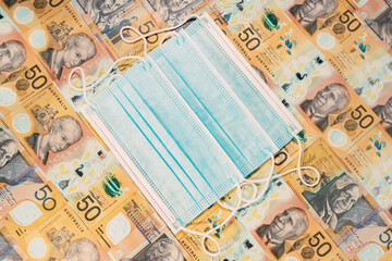 Disposable face mask over an australian dollar background.
