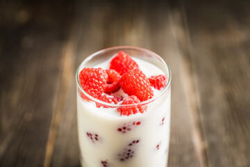 Milk with raspberry in the glass. Selective focus. Shallow depth of field.