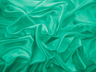 Beautiful elegant wavy light green satin silk luxury cloth fabric texture, abstract background design. Card or banner.