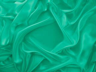Beautiful elegant wavy green satin silk luxury cloth fabric texture, abstract background design. Card or banner.