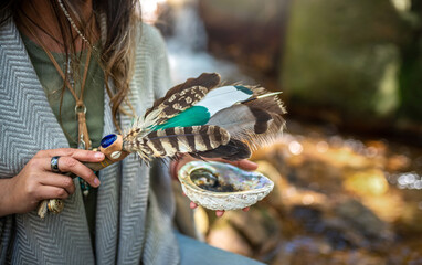 Woman performing a smudging ceremony in a forest