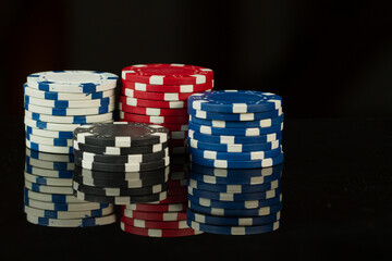 Various colors casino playing poker chip isolated on black background.