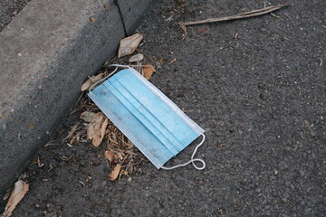 A disposable face mask discarded in the gutter during the COVID19 pandemic.