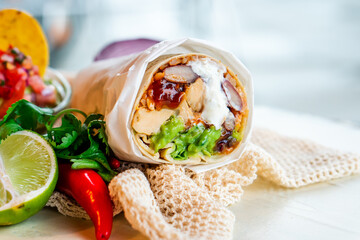 Mexican traditional authentic homemade Burrito with pulled pork beef chili con carne serve with tomato salad and avocado guacamole and dip sauce