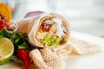 Mexican traditional authentic homemade Burrito with pulled pork beef chili con carne serve with tomato salad and avocado guacamole and dip sauce