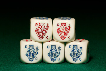 Playing poker dice full house closeup on green background