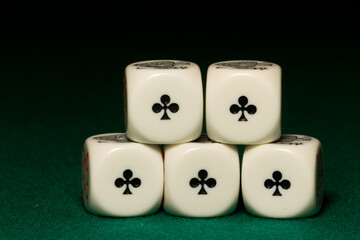 Playing poker dice aces closeup on green background