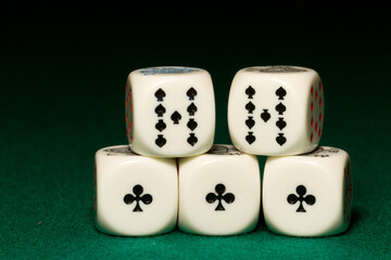 Playing poker dice Full House closeup on green background