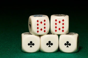 Playing poker dice Full House closeup on green background