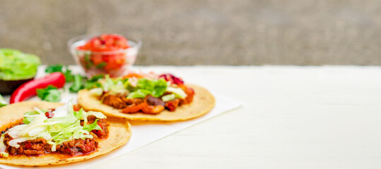 Mexican traditional authentic homemade tacos with pulled pork beef chili con carne serve with tomato salad and avocado guacamole and dip sauce