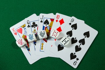 Playing Card Straight and Poker Dice laying on green table background with space for text. Abstract Pattern