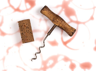 Corkscrew and and cork with wine stains isolated on white