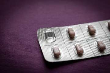 Package of pills on a purple background. Close up. Selective focus.