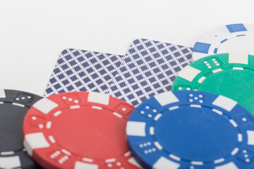 Two Playing Cards Turned Up Side Down and various color Poker Chips. Pattern Isolated on White Background.