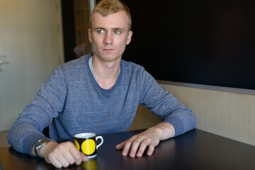 Portrait of young man with blond hair relaxing at home