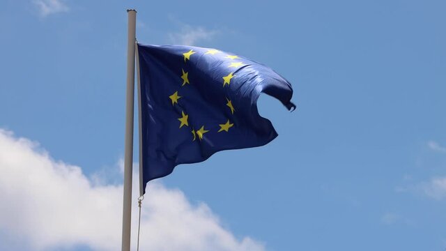 Footage of an EU European flag and flag poole blowing in the wind on a bright sunny summers day taken in the Spanish island of Ibiza