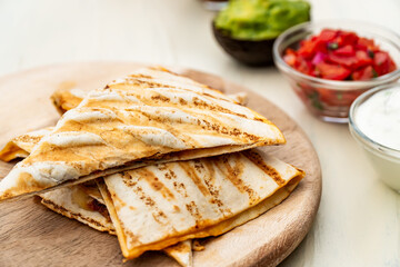 Mexican traditional authentic homemade quesadilla with pulled pork beef chili con carne serve with tomato salad and avocado guacamole and dip sauce