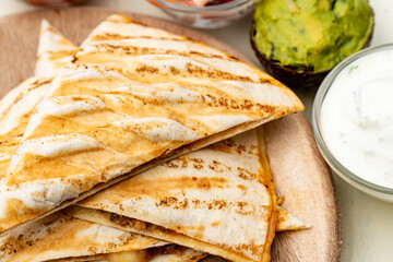 Mexican traditional authentic homemade quesadilla with pulled pork beef chili con carne serve with tomato salad and avocado guacamole and dip sauce