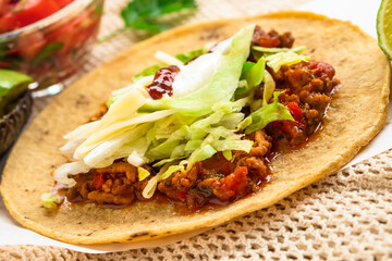 Mexican traditional authentic homemade tacos with pulled pork beef chili con carne serve with tomato salad and avocado guacamole and dip sauce