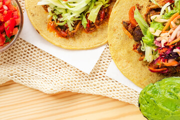 Mexican traditional authentic homemade tacos with pulled pork beef chili con carne serve with tomato salad and avocado guacamole and dip sauce