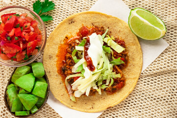 Mexican traditional authentic homemade tacos with pulled pork beef chili con carne serve with tomato salad and avocado guacamole and dip sauce