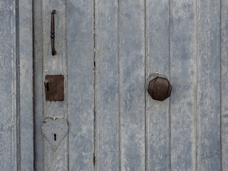 Detail of an old wooden door with rusty fittings