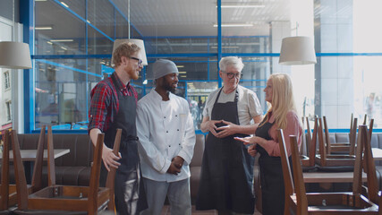 Multiethnic restaurant staff talking before opening