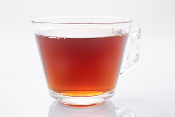 Black tea in a glass cup on a white background