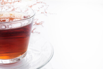 Black tea in a glass cup on a white background