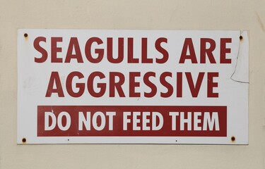 A seagull warning sign beside fast food shops.