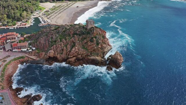 View from flying drone. Sunny morning cityscape of Porto town with Genoise de Porto Ota tower. Aerial spring view of Corsica island, France, Europe. 4K video (Ultra High Definition).
