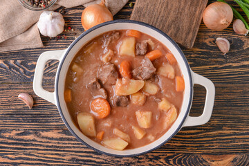 Pot with tasty beef stew on table