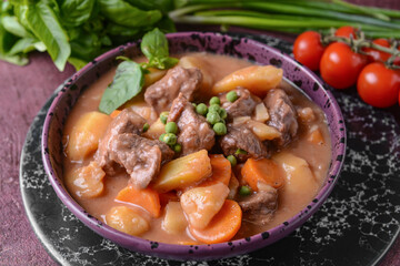 Bowl with tasty beef stew on table