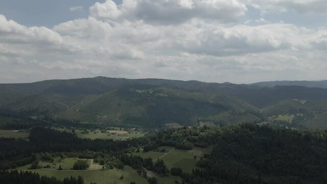 Aerial shot of  mountains meadow in Beskidy, flying over gravel road in Rajcza.