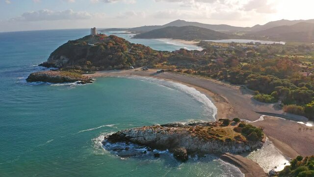 View from flying drone of popular tourist destination - Acropoli di Bithia with Torre di Chia tower on background. Sunny morning view of Sardinia island, Italy, Europe. 4K video (Ultra High Definition