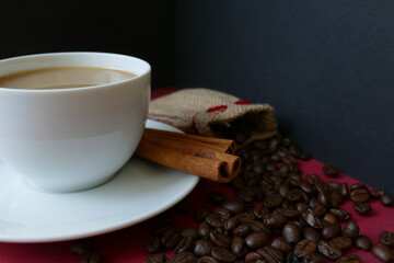 Kaffeetasse mit Zimtstangen und Kaffeebohnen