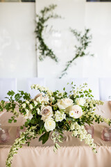 Vertical photo of presidium with floral arrangement with fresh white rose of the newlyweds at the wedding