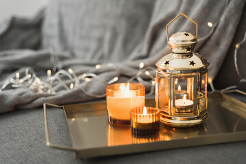 Metal lantern and burning candles on a golden metal tray. Eid al Adha celebration. Muslim holiday...