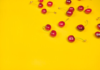Fresh and organic red cherries on a bright yellow background, healthy living, summer lifestyle