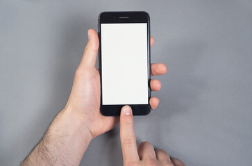 Man holding mobile device in a hand with white black space on the screen, using technology 