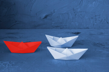 Red Leader Paper Boat Leading Group Of Paper Boates on gray background. Leadership Business for innovative solution concept.