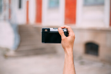 a person taking photos with compact camera in summer on the street