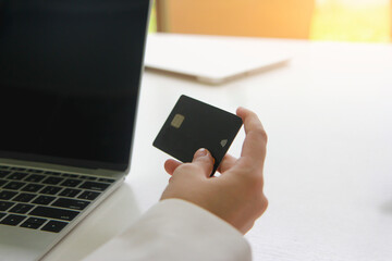 Woman holding credit card for online shopping on computer laptop.